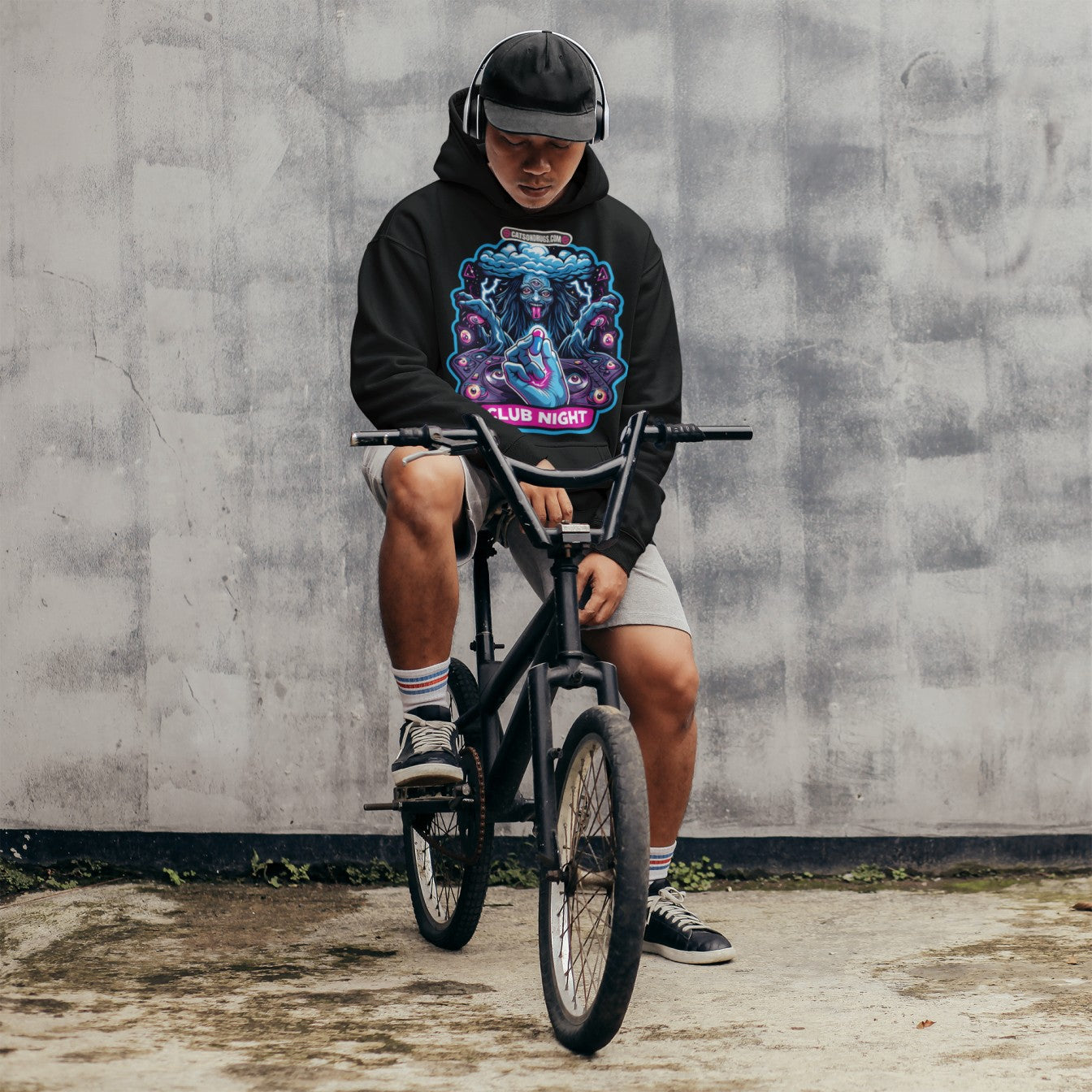 Unisex model wearing Underground Clothing Club Night Hoodie styled with denim at night